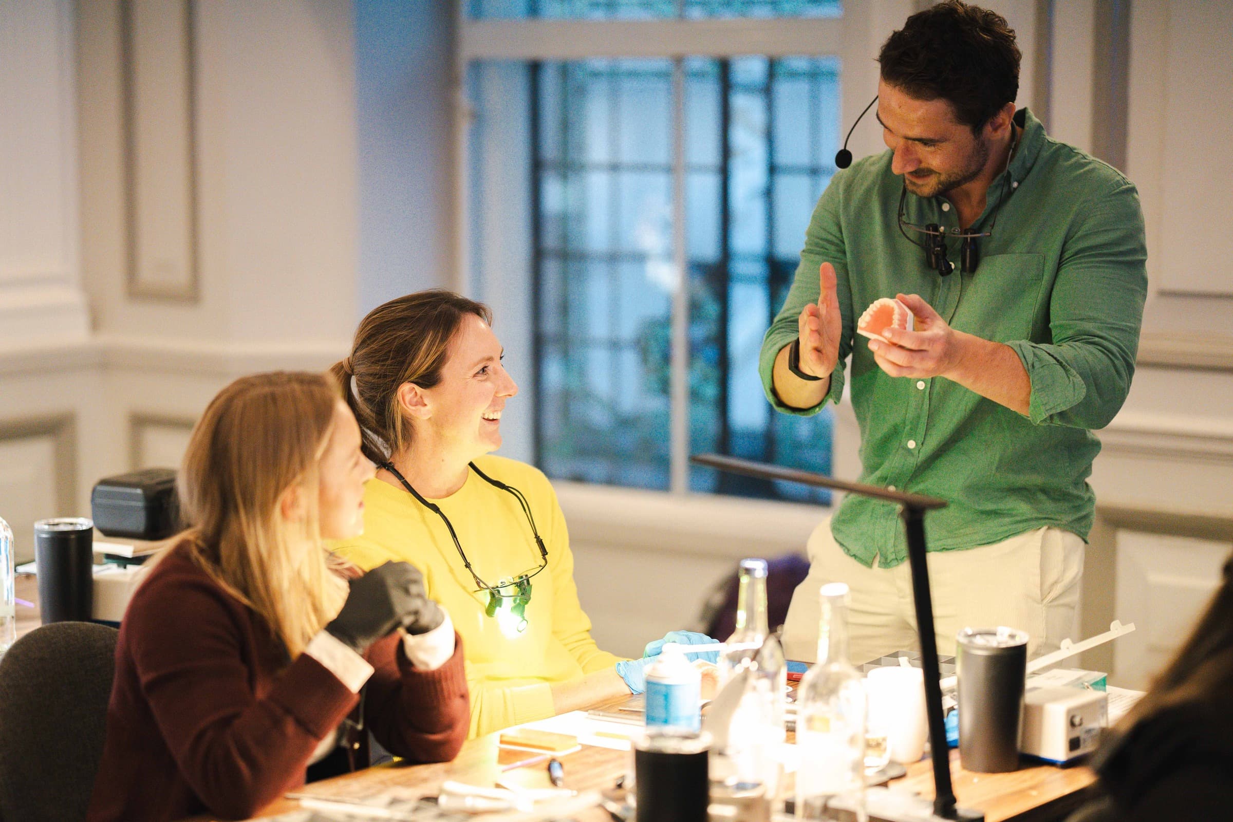 Dr Albert explaining a case to two smiling delegates at a Simplifi course